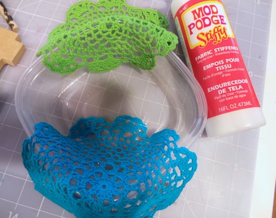 Two doilies on the edge of a plastic bowl with Mod Podge Stiffy