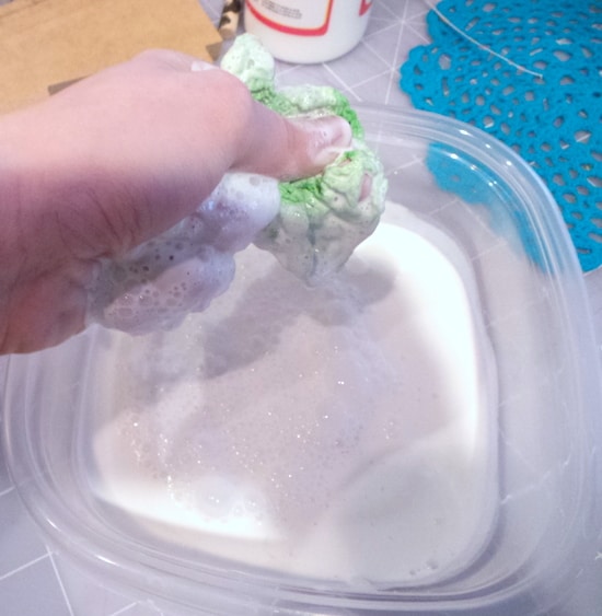 Squeezing a doily out into a plastic container