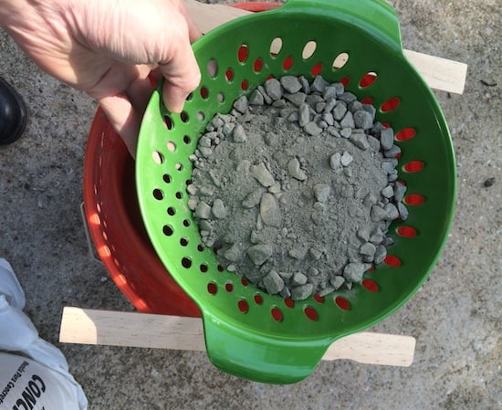Concrete being sifted through a colander
