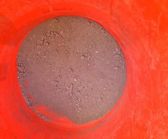Fine particles of concrete at the bottom of a bucket