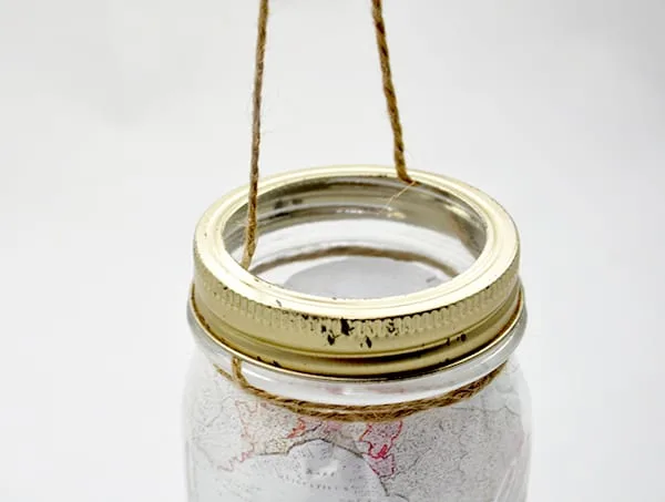 Gold ring screwed down on the top of the mason jar with the twine