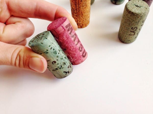 Pressing two wine corks together with fingers