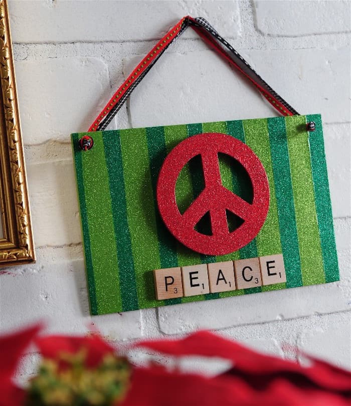 This holiday sign uses some of my favorite craft supplies - scrabble tiles, glitters, and the peace symbol. It's the perfect holiday display!