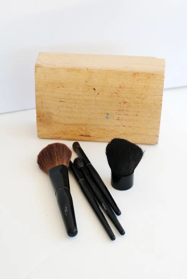 a block of pine wood and several makeup brushes