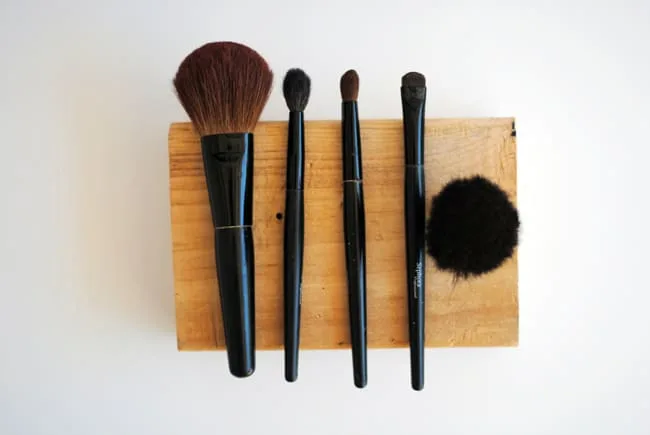 Makeup brushes laid out on a block of wood