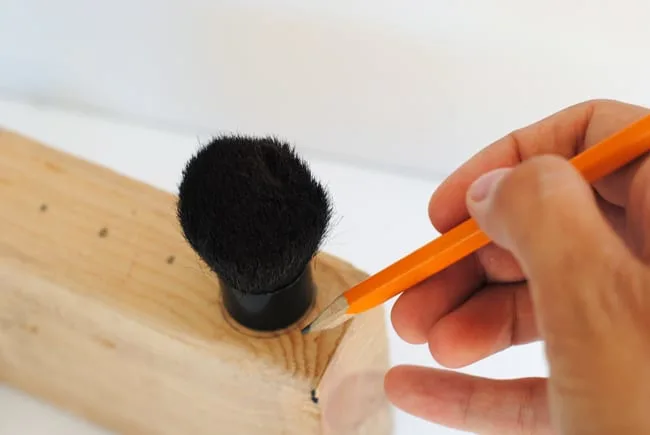 Trace the base of a kabuki makeup brush with a pencil onto a block of wood