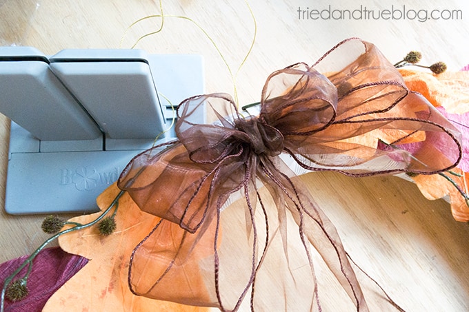 Adding a bow made with a Bowdabra to a DIY fall wreath