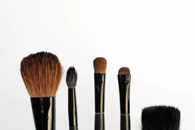 The tops of makeup brushes at various heights
