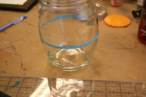 Adding stencil tape to the center of a mason jar