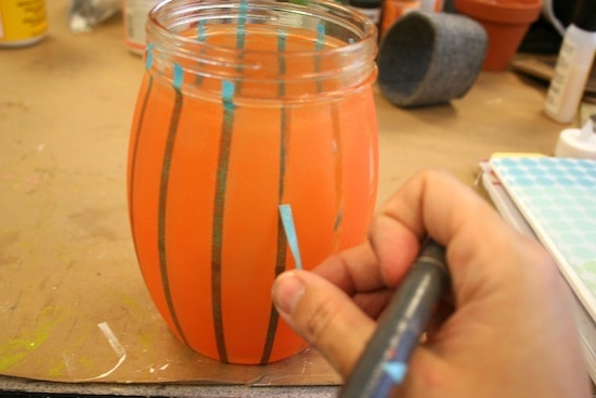 Peeling stencil tape off a painted jar
