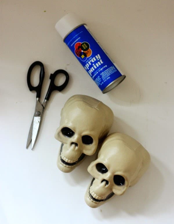 Plastic dollar store skulls, scissors, and a can of spray paint