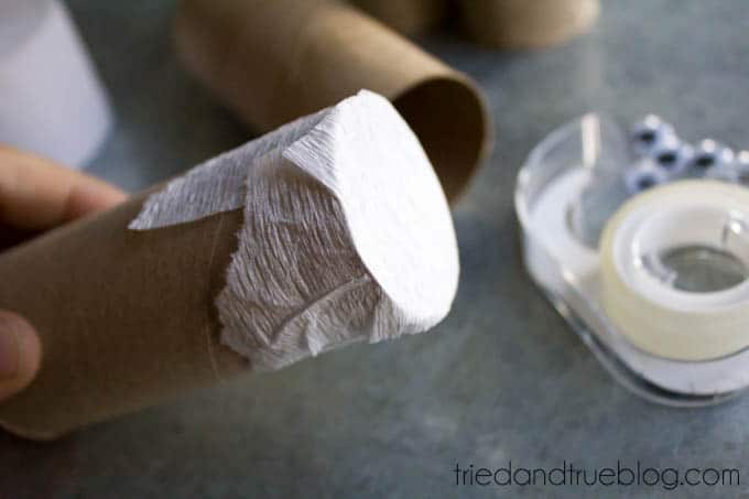 Taping the end of a toilet paper roll with crepe paper