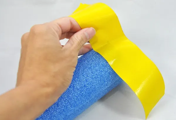 Wrapping duct tape around the end of a pool noodle