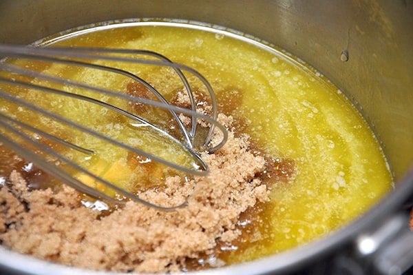 Whisking brown sugar into melted butter in a saucepan