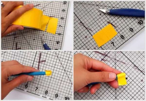 Yellow duct tape being rolled onto the end of a pen