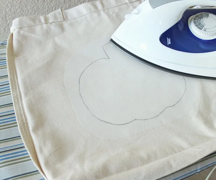 Ironing the interfacing onto a bag with an iron