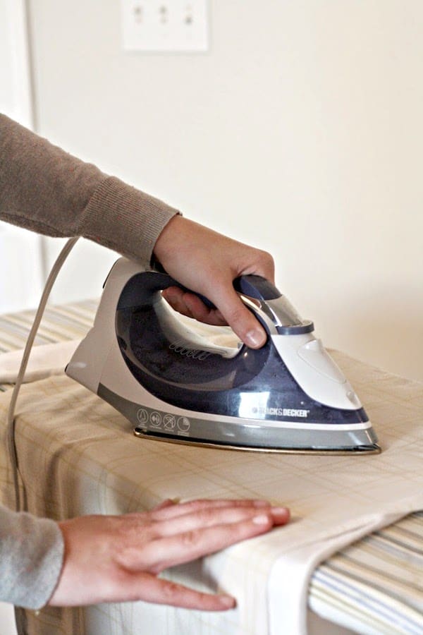 Ironing gold circles onto a shirt with a towel between the shirt and the iron