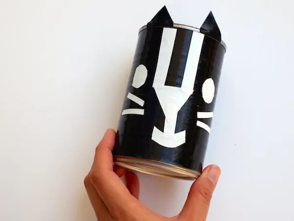 Turning a tin can into a cat container with black and white duct tape