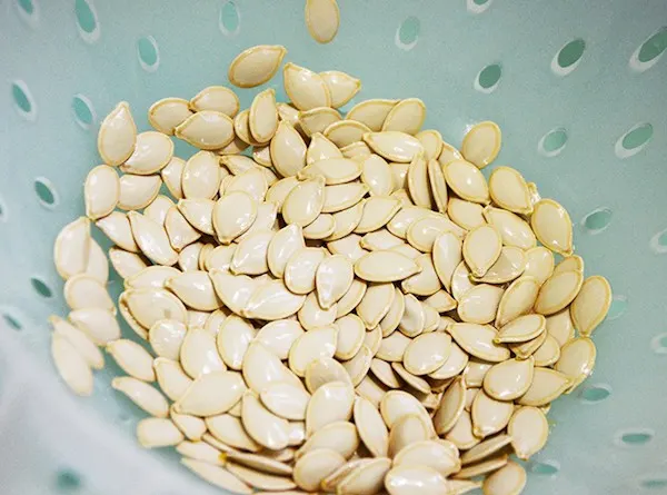 Pumpkin seeds in a strainer that have been rinsed
