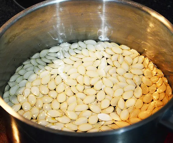 Pumpkin seeds on the stove in a pot covered by water