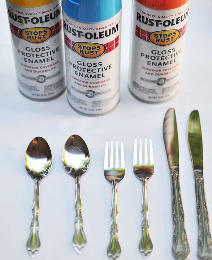 Two spoons, two forks, and two knives along with three cans of spray paint