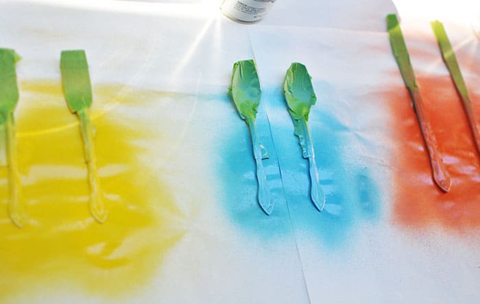 Knives, spoons, and forks spray painted with color