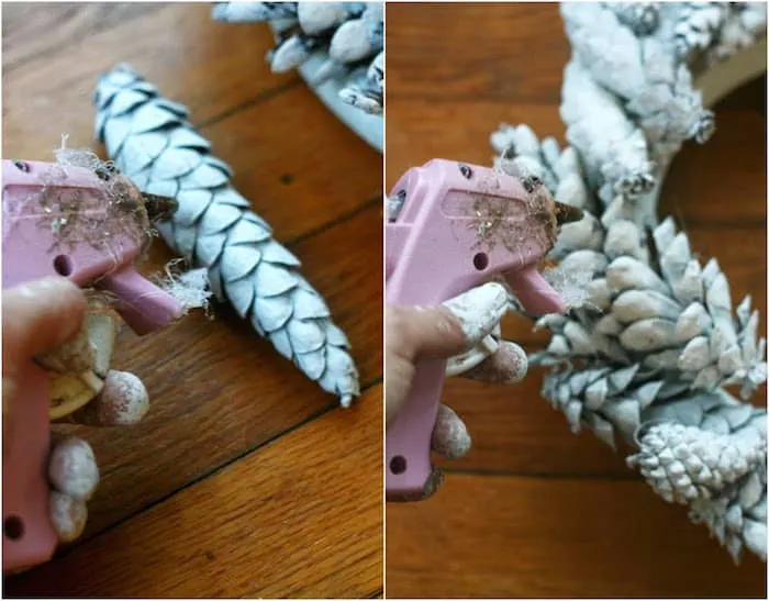 Hot gluing pinecones to a wreath form