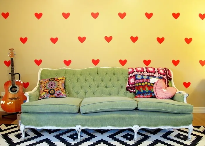 DIY temporary wall decals with a green couch and a black and white rug