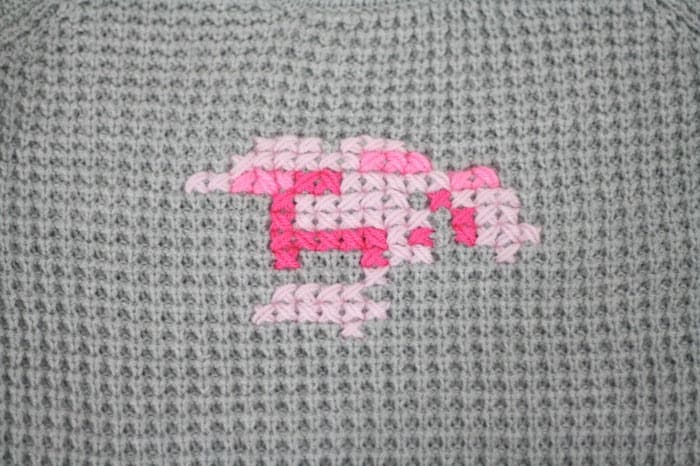 Partial cross stitch design on the front of a sweater