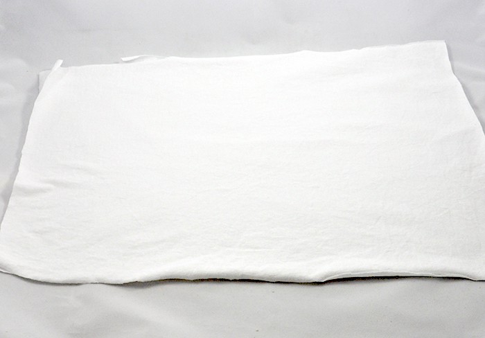 White piece of t-shirt laid out on a surface