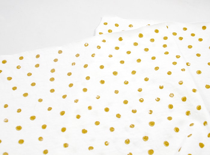 Gold dots painted on t-shirt material