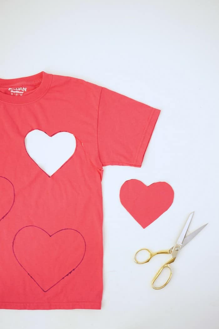 Cutting hearts out of the red t-shirt with scissors