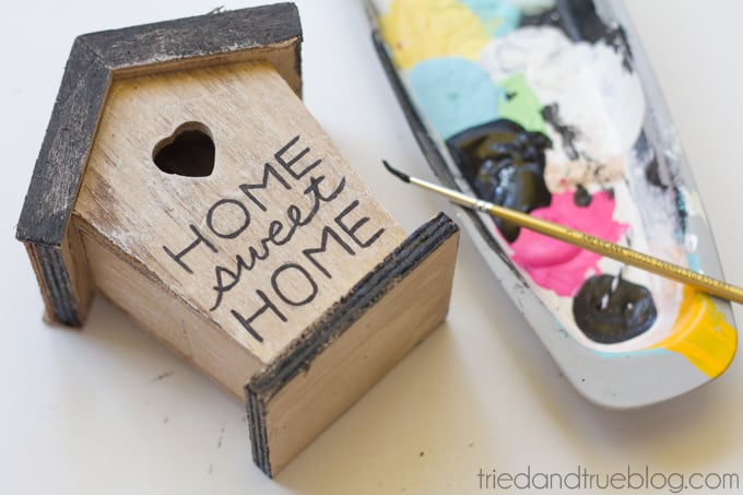 Home Sweet Home painted on the front of a wood birdhouse