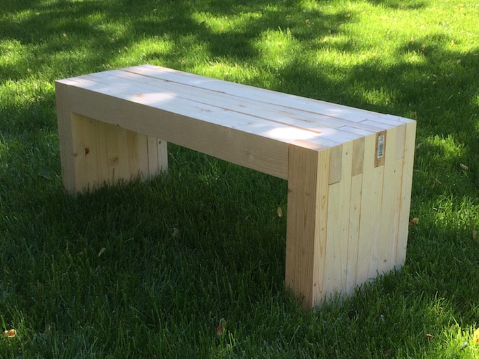 Unstained, finished bench sitting in the middle of grass