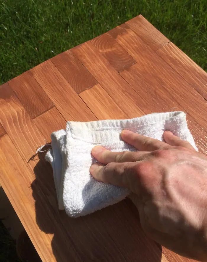 Removing excess stain from the wood with a rag