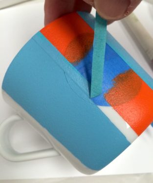 Removing the thin painter's tape from the mug