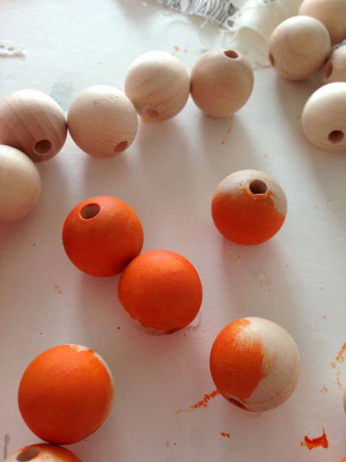 Painting wood beads with orange paint