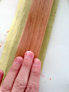 Smoothing the wood slat down onto the fabric