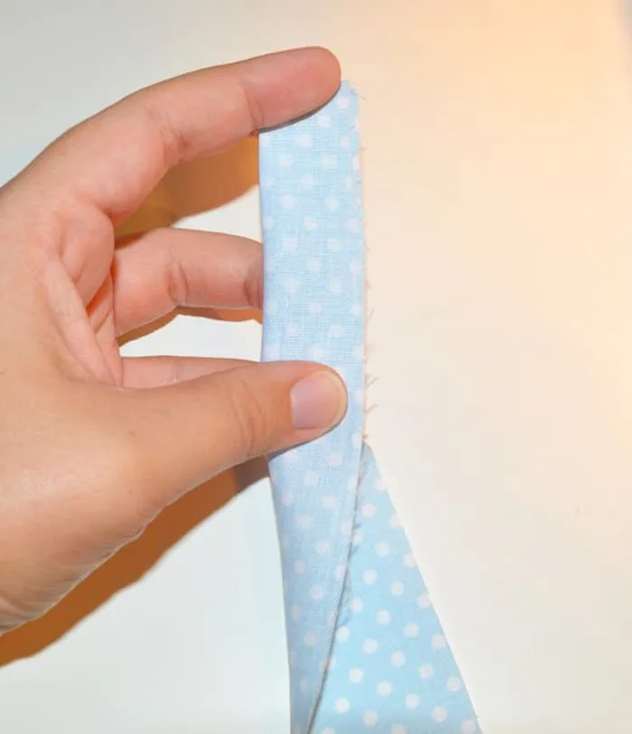 Folding polka dot fabric in half lengthwise