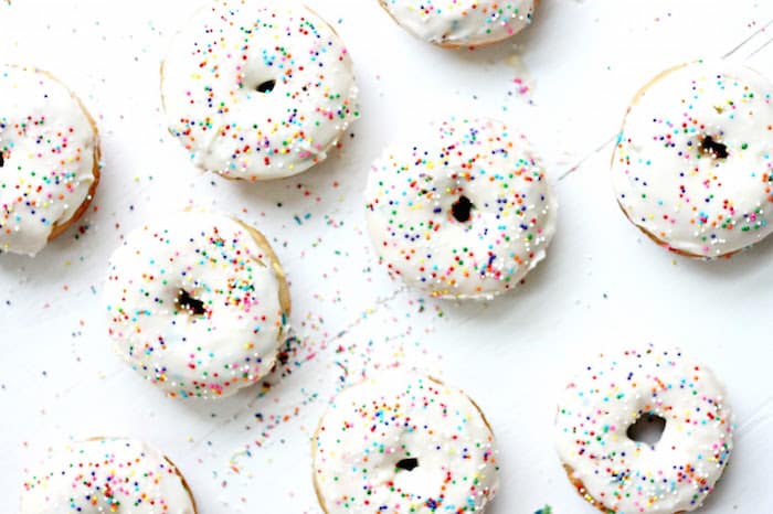 Vanilla frosted baked donuts with rainbow sprinkles