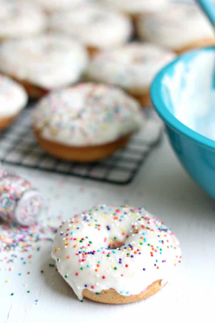 Baked donut with rainbow sprinkles laying on the table