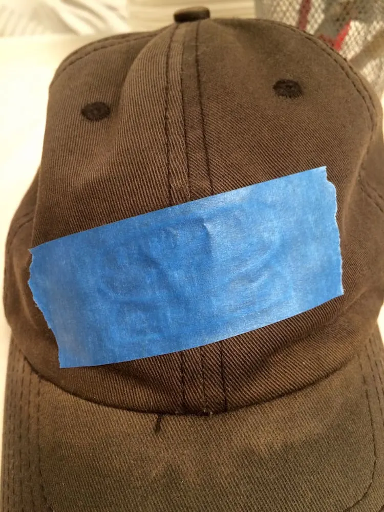Logo on a hat taped with painter's tape