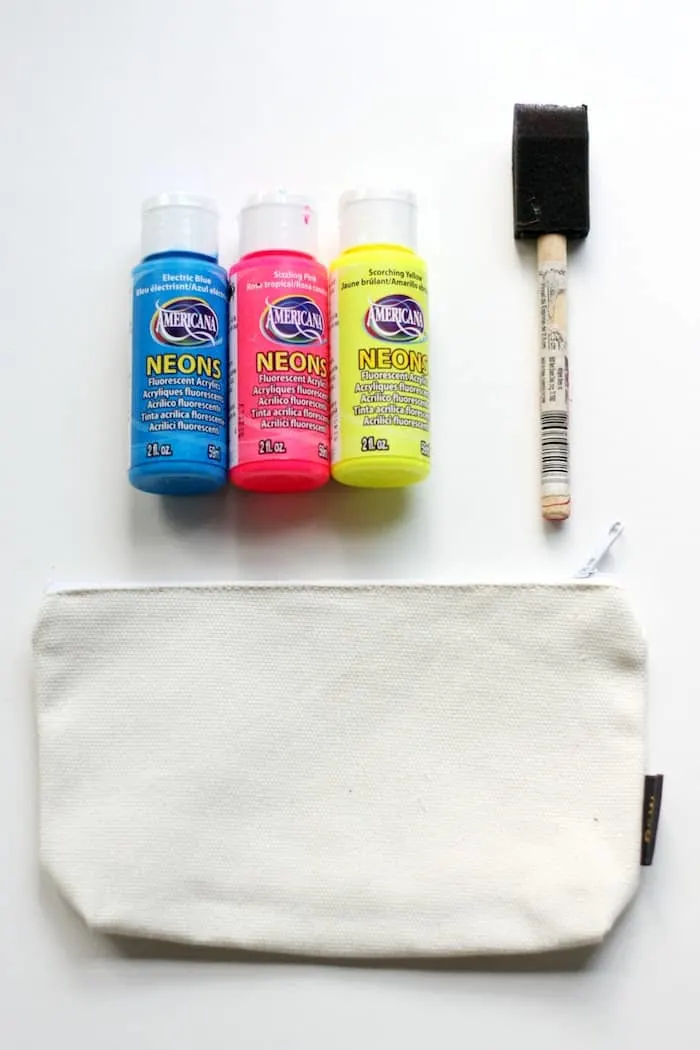Acrylic paint, foam brush, and a blank canvas pouch