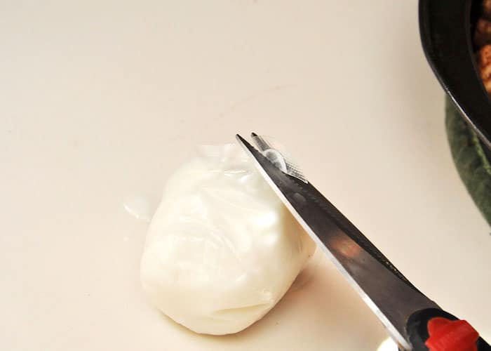 Cut the frosting bag open with a pair of scissors or a knife
