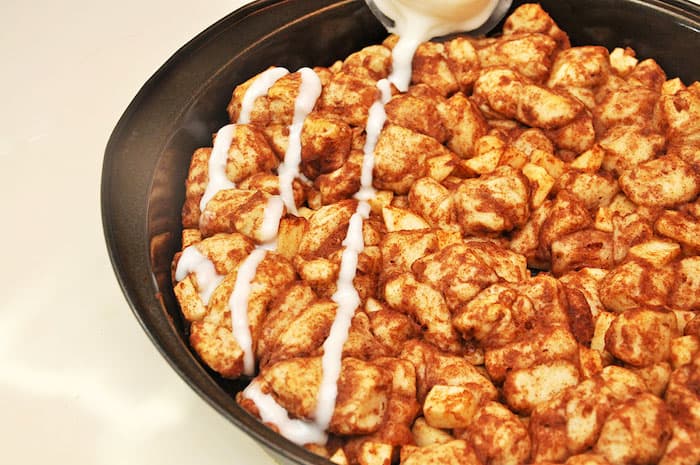 Drizzling frosting over apple cinnamon monkey bread