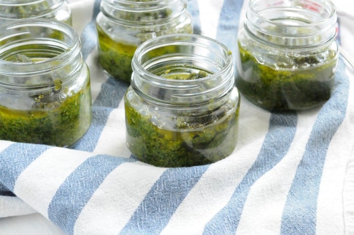 Delicious homemade pesto with olive oil, basil, and pine nuts in jars