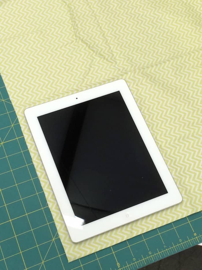 iPad laying on a light green patterned piece of fabric