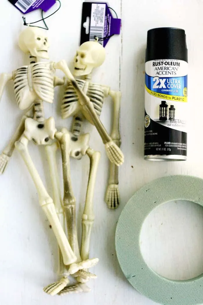 Plastic Dollar Tree skeletons, a wreath form, and black spray paint