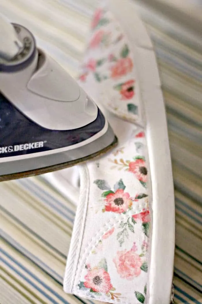Ironing a floral design onto a white canvas shoe