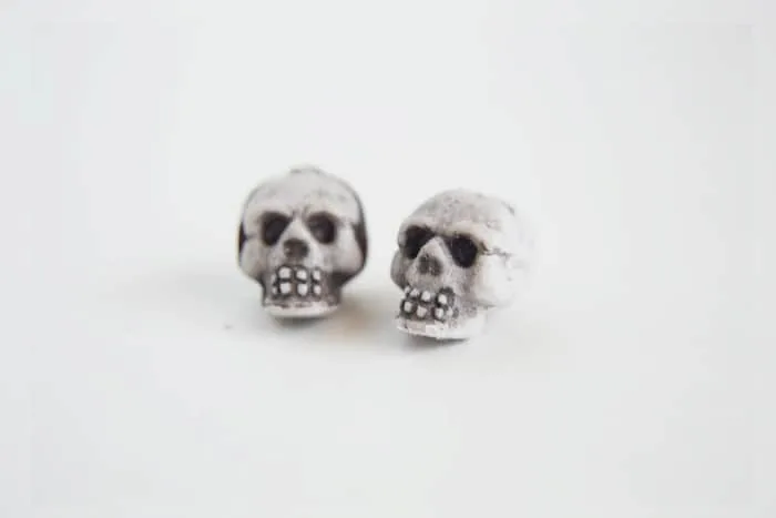 Two skull beads sitting on a white background